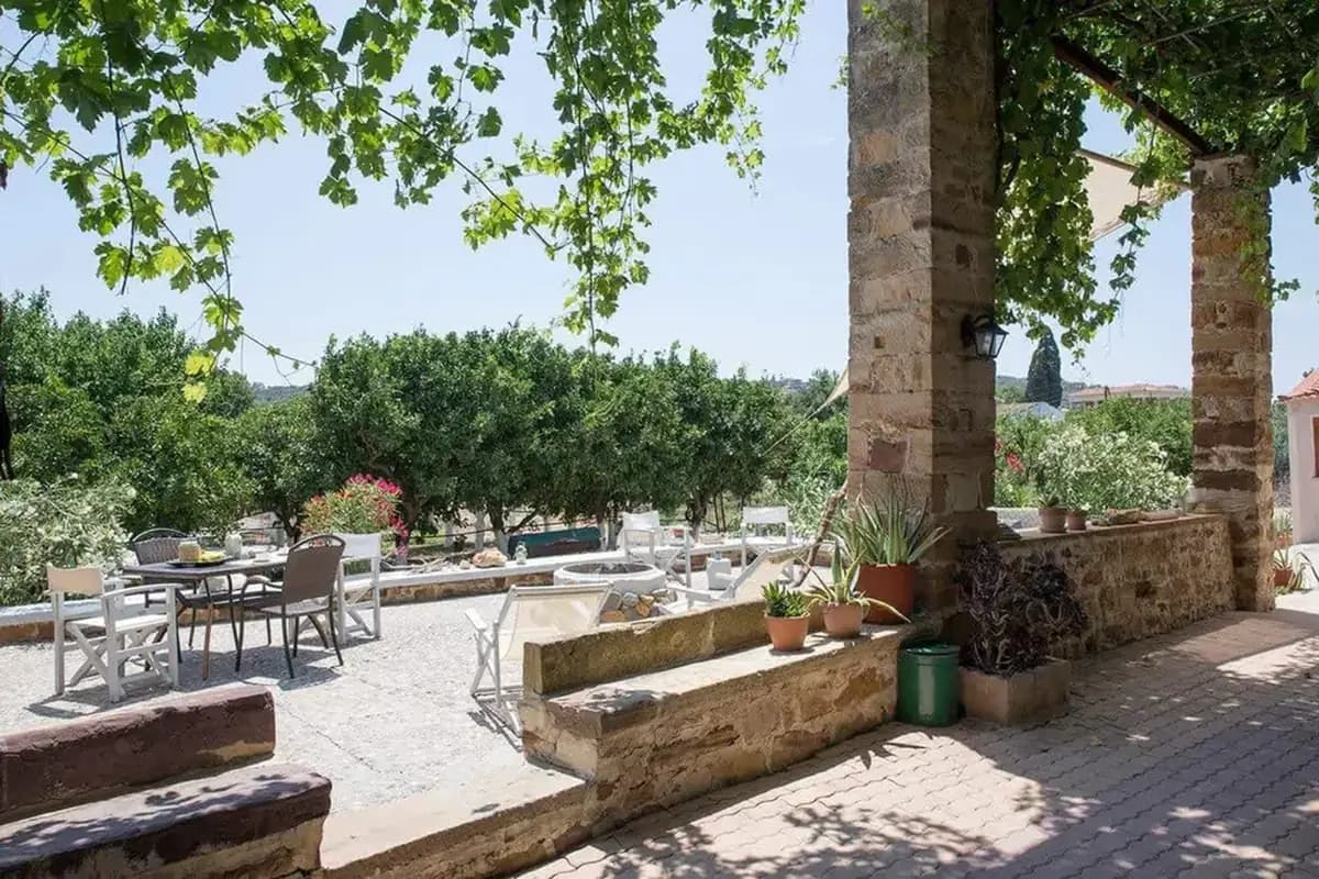 Shaded garden courtyard with tables at Voulamandis House in Kampos, Chios